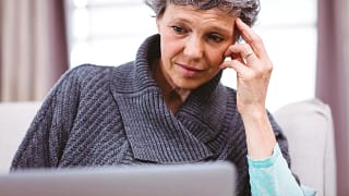 mature woman looking at laptop computer with raised eyebrows and thinking confused doubtful uncertain unsure skeptical.jpg