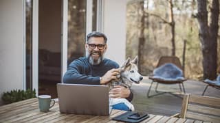 older man at laptop with dog gettyimages .jpg