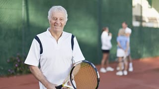 older man holding tennis racket gettyimages .jpg