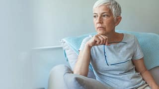 person sitting in a chair holding eyeglasses.jpg