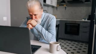senior man laptop kitchen serious gettyimages .jpg