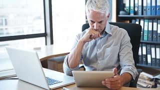 older man desk tablet serious gettyimages .jpg