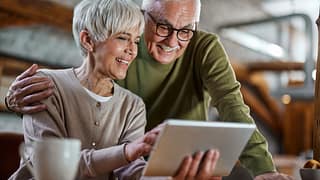 smiling couple looking at tablet together.jpg