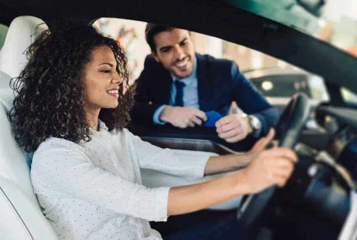 woman in car with salesman Geqvxx.width .jpg
