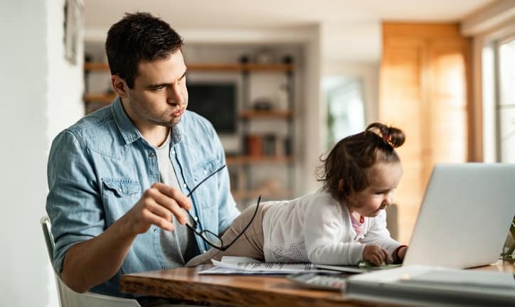 stressed dad working at home with baby.width