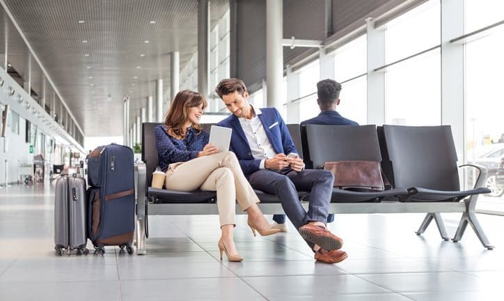 man and woman sitting at airport opGWJ.width .jpg