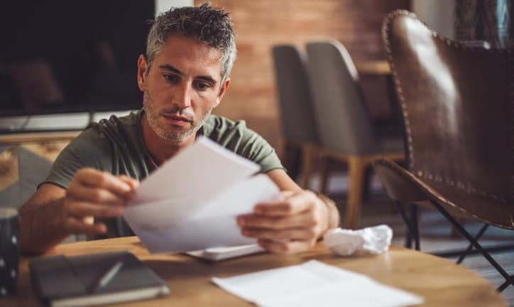 man with bills at desk fggd.width .jpg