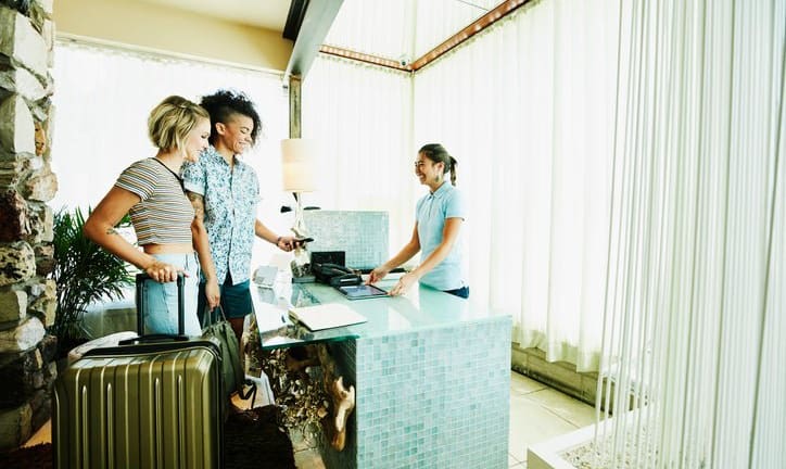 two women checking into hotel VFnxxdU.width .jpg