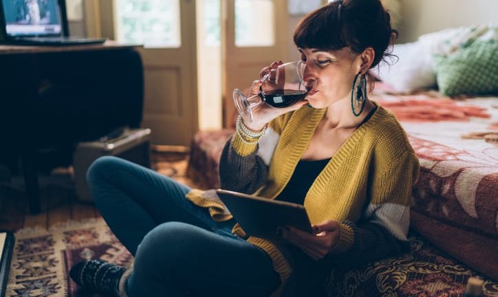 woman with wine watching movie on tablet.width .jpg