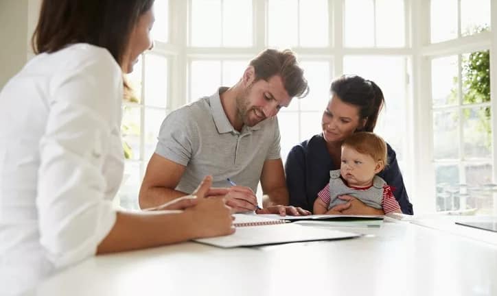 couple with baby signing house closing docume.width .jpg