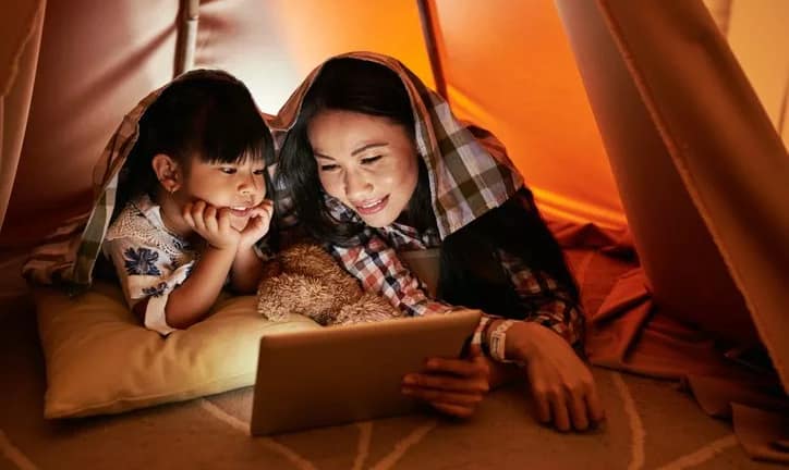 mom and young daughter watching movie on tabl.width .jpg