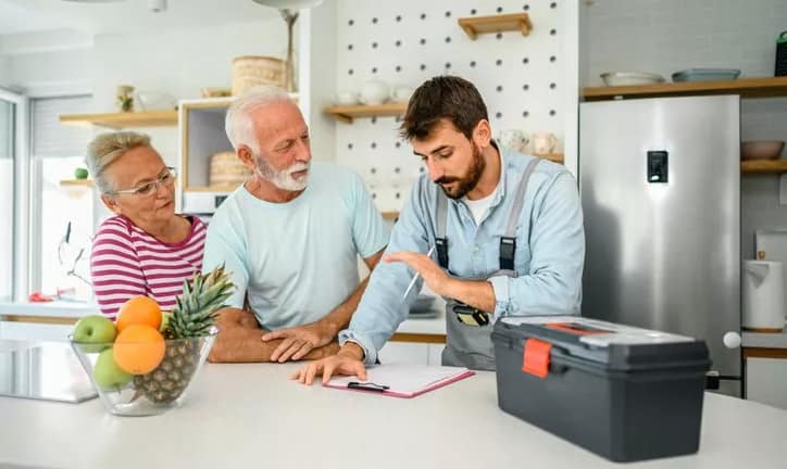 repairman talks to couple in kitchen KLkHSy.width .jpg