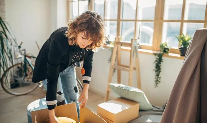 woman packing moving boxes in apartment Pedi.width .jpg