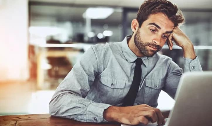 bored man working at computer at office job.width .jpg