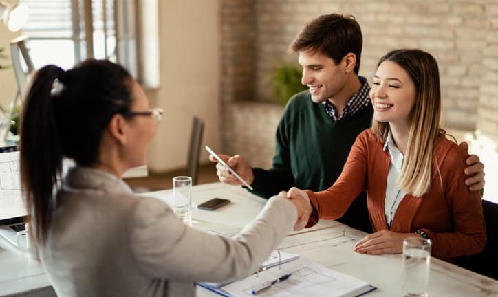 couple signing mortgage and shaking hands wit.width .jpg