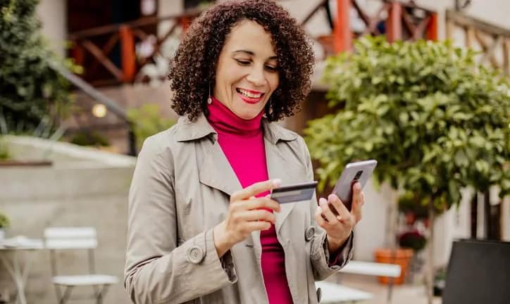 woman holding credit card and phone vpiLZ.width .jpg