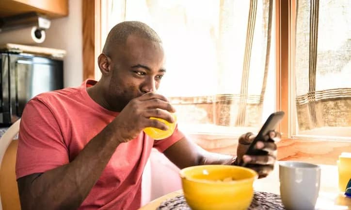 man holding phone eating breakfast EnRgBMr.width .jpg