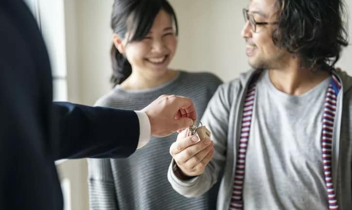 realtor handing couple house keys.width .jpg