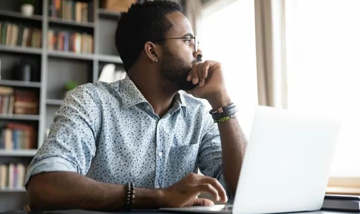 worried man at laptop looking out window.width .jpg
