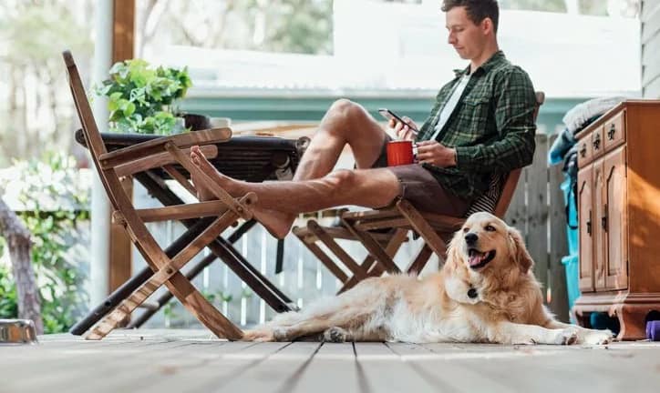 man on porch with dog phone coffee ORGJVJC.width .jpg