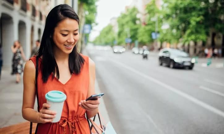 woman on street with phone and coffee.width .jpg