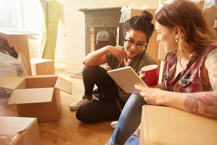 two women with moving boxes and tablet IrIKZ.width .jpg