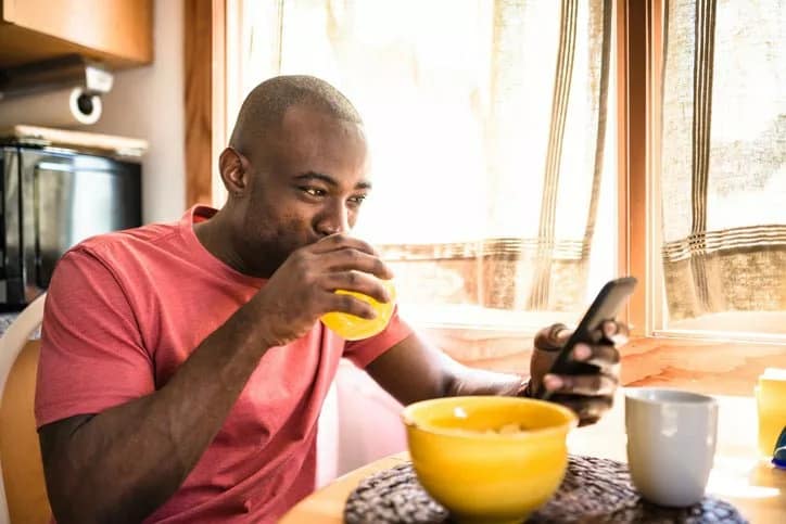 man holding phone eating breakfast EnRgBMr.width .jpg