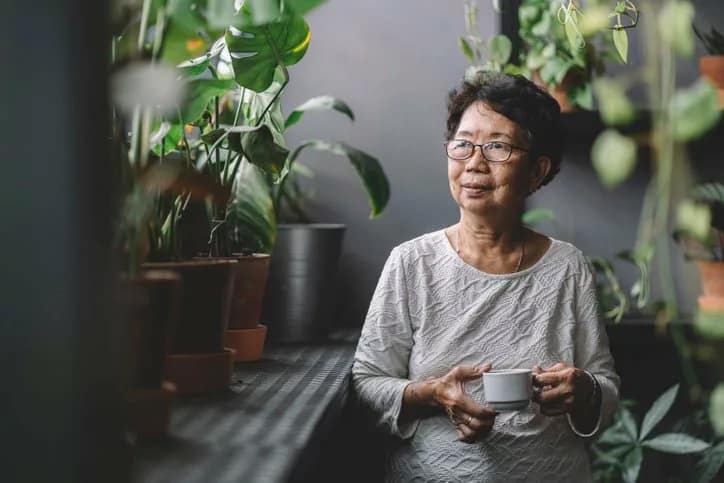 woman drinking tea near houseplants rpwlRul.width .jpg