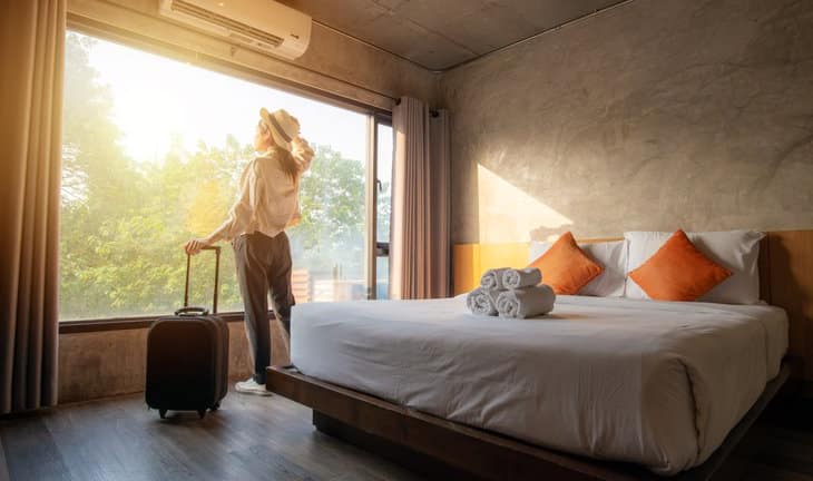 woman with suticase at hotel room window.width .jpg