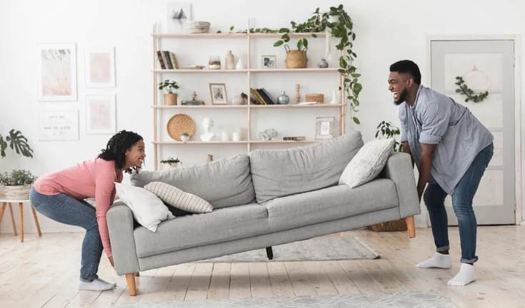 man and woman moving couch in living room MHH.width .jpg