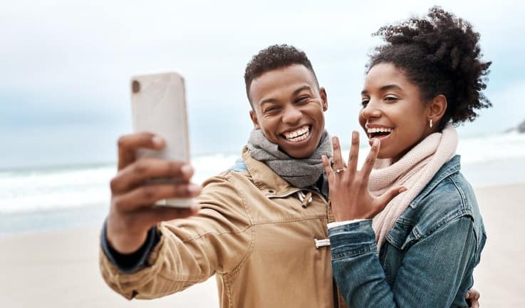 engaged couple on beach.width