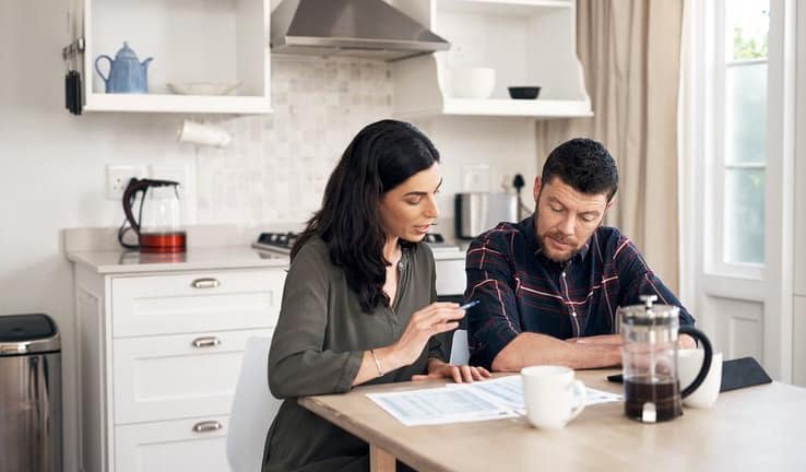 couple talking over papers in kitchen KRXubp.width