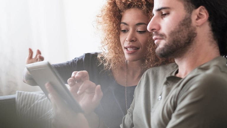 Couple looking at something together on a tab.width PsznaUo