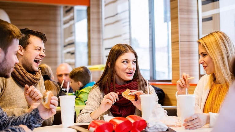 Group of friends eating fast food burgers and.width .jpg