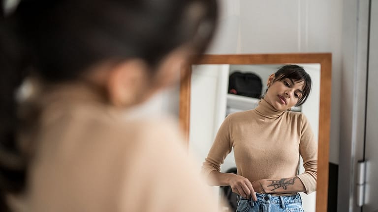 Person trying on clothing in mirror. EambWvL.width
