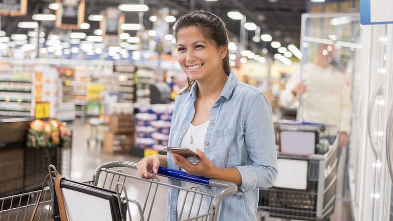 Smiling warehouse store club shopper with pho.width