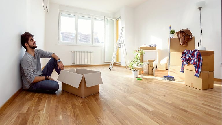 Young man empty apartment boxes imMTFem.width
