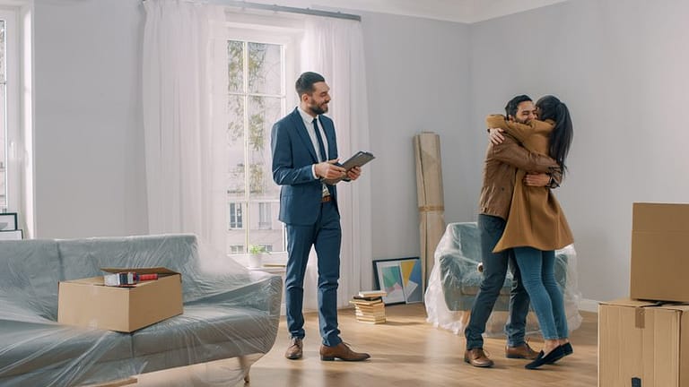 couple hugging in house with realtor.width .jpg