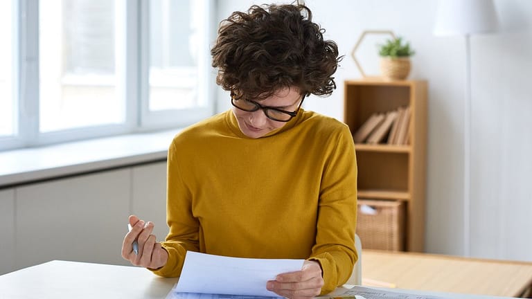 person with pen and paperwork RhgBV.width