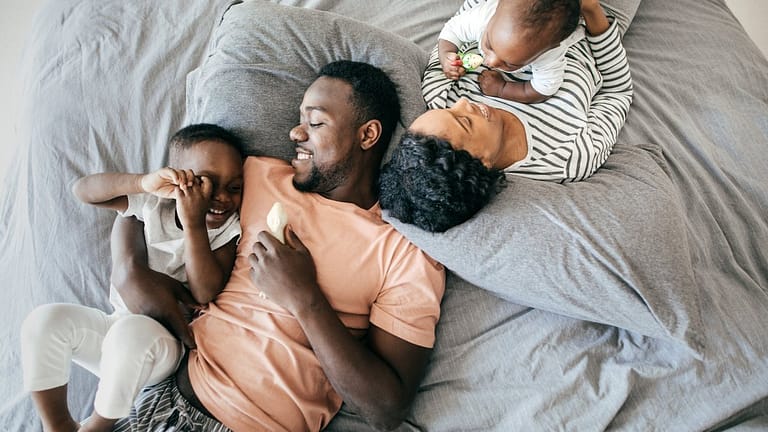 two parents with young kids on bed HxMda.width .jpg