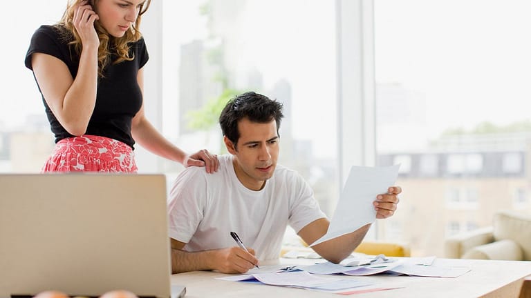 two worried people at kitchen table with bill.width MIUbkr