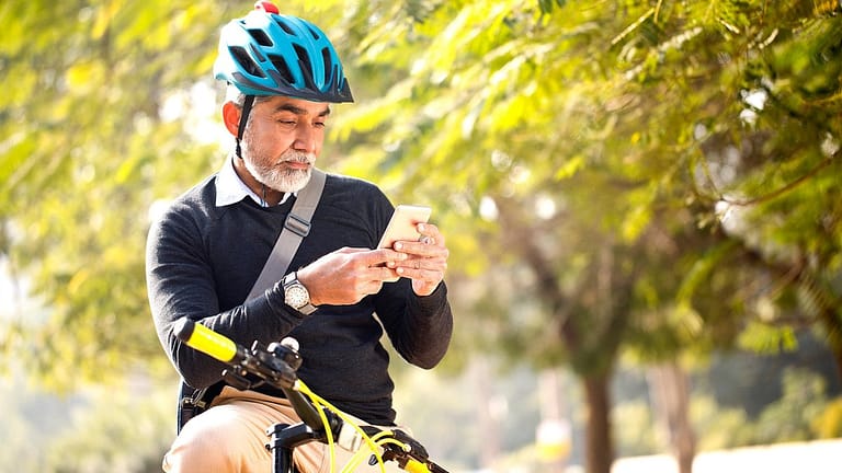 Man looking at his cell phone while riding hi.width TIdVD.jpg