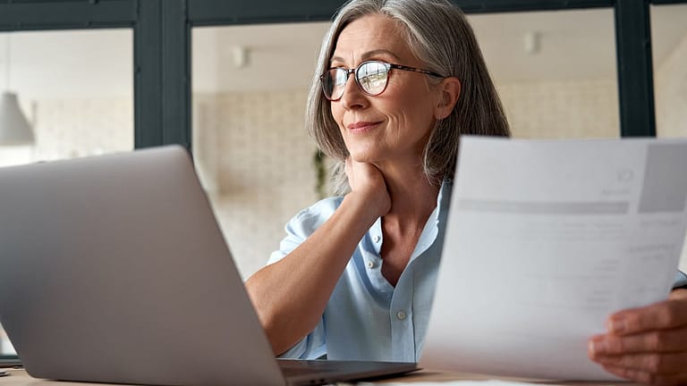 Mature woman working from laptop with documen.width ZiqNtKV.jpg