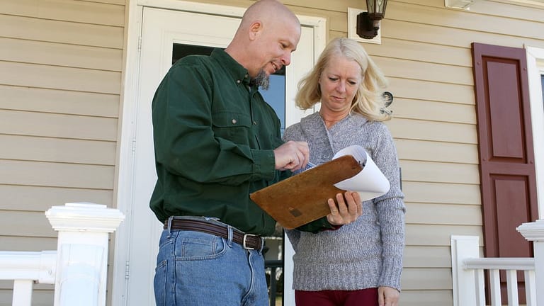 Woman on porch talking to man with clipboard .width .jpg