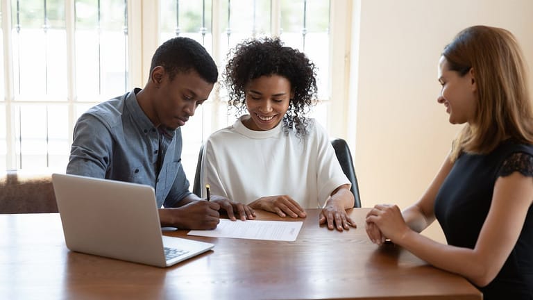 Young couple signing papers with an agent aq.width .jpg