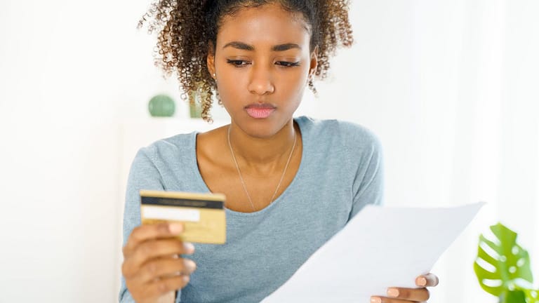 Young woman looking at credit card uQDfnW.width .jpg
