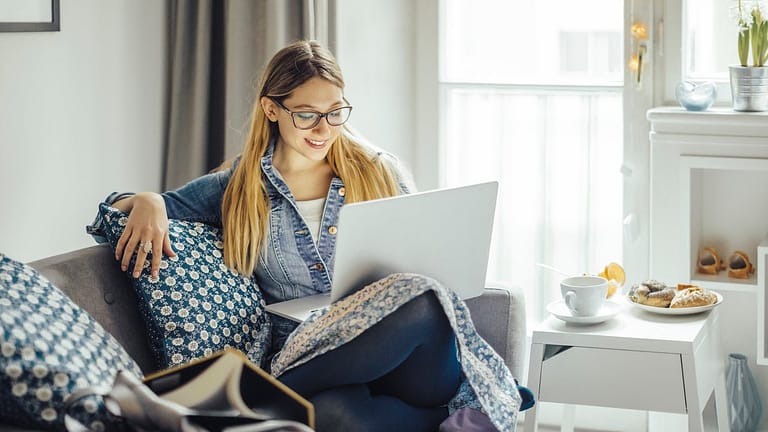 Young woman using laptop on the couch. KUYgdG.width .jpg