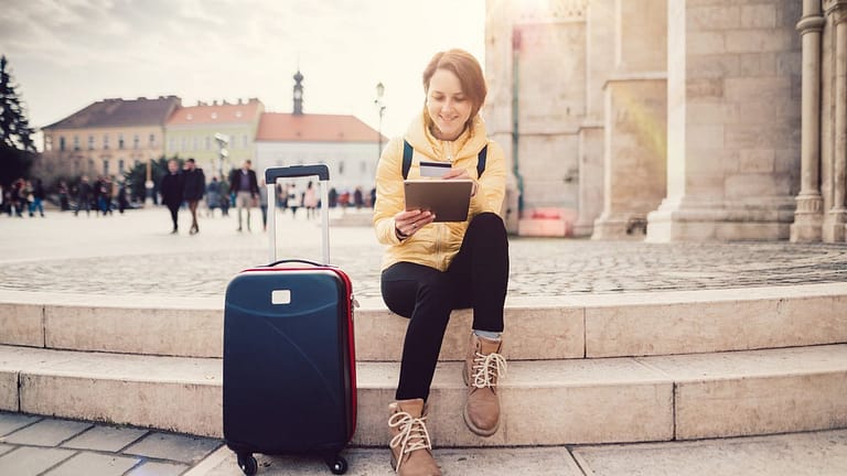 female traveler with suitcase tablet and cred.width sQbWMG.jpg