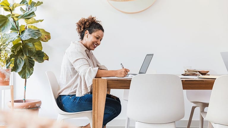 person at dining table writing in notebook TR.width .jpg