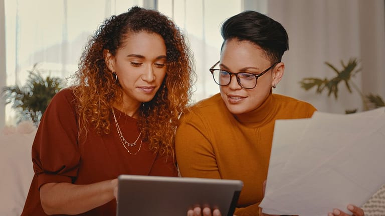 two people looking at tablet and paperwork aL.width .jpg